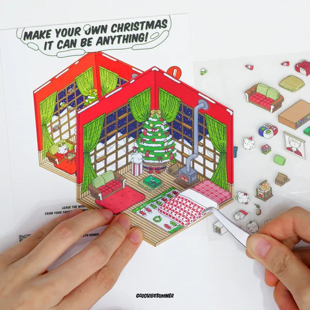 Hands placing a sticker into a Christmas-themed GOODVIBESUMMER miniature room
